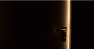 暗い部屋のドアから光が差し込んでいる